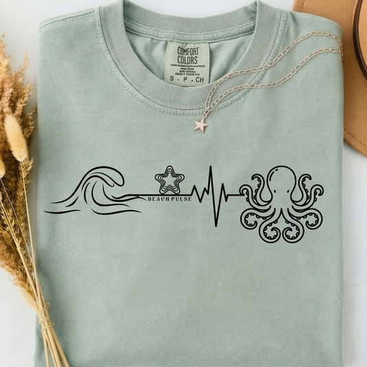 green comfort colors t-shirt with ocean-themed, beach waves, heartbeat, starfish and Octopus design along with a minimalist 'Beach Pulse' text.