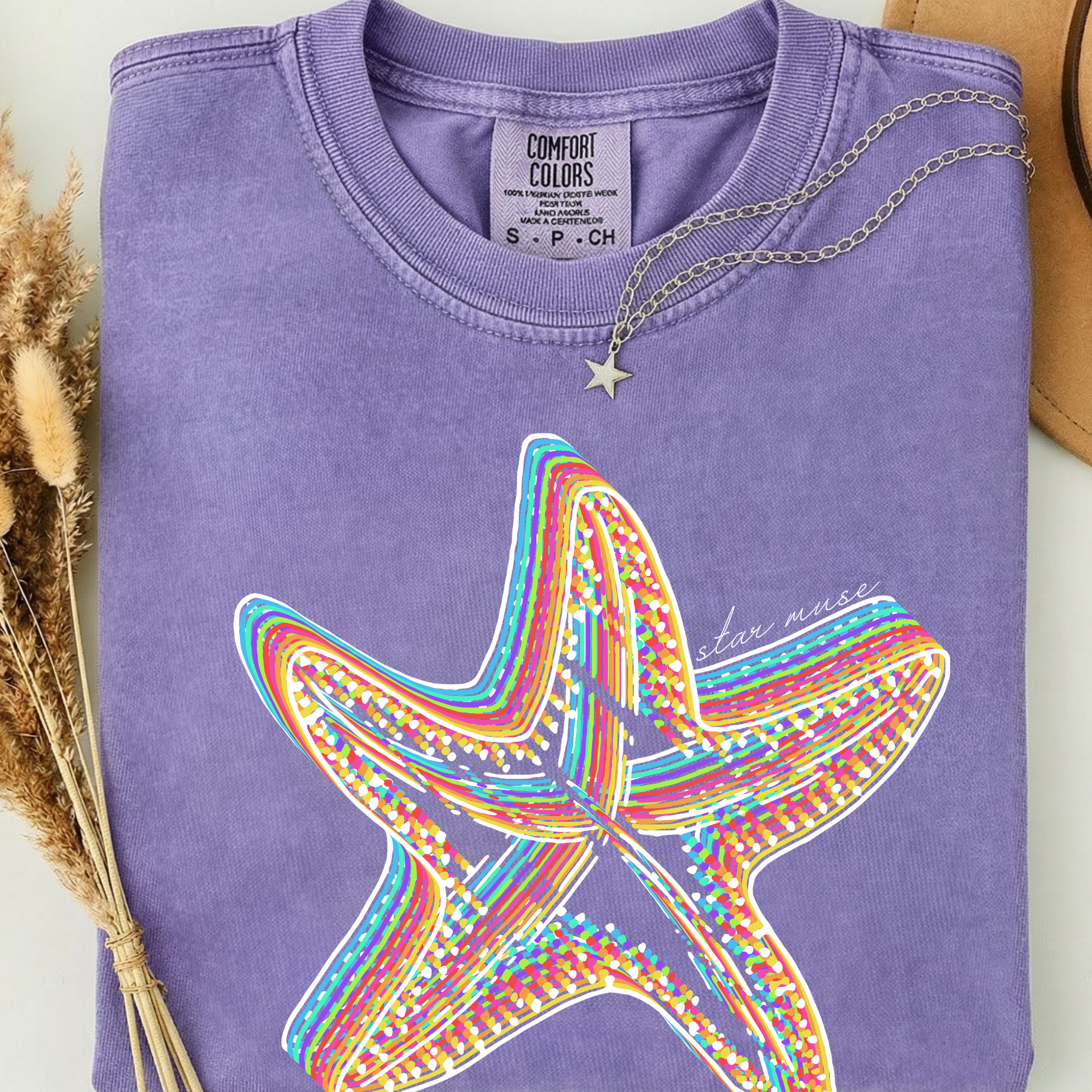 Purple comfort colors t-shirt with a colorful rainbow starfish design. 